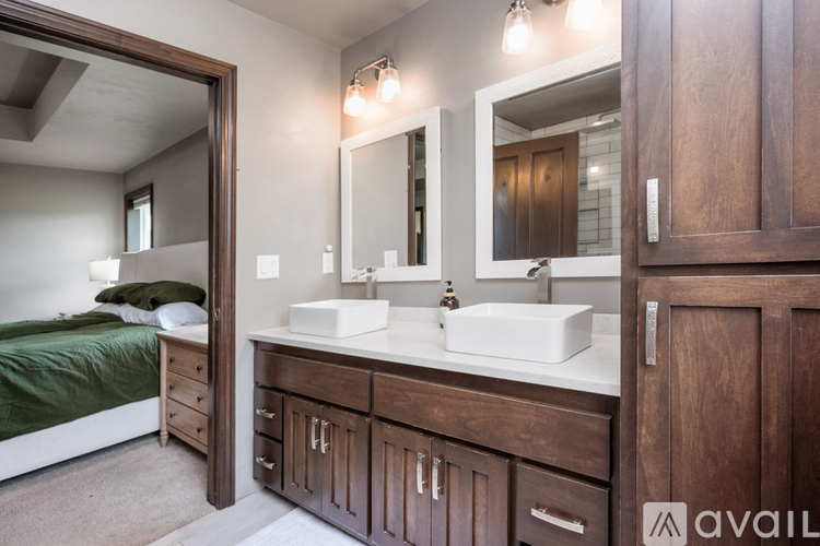 A bedroom with a large mirror above a double sink vanity.