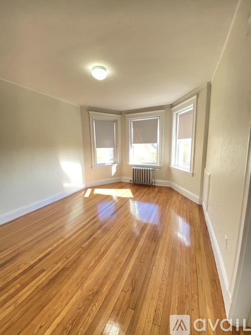 A room with wooden floors and two windows.