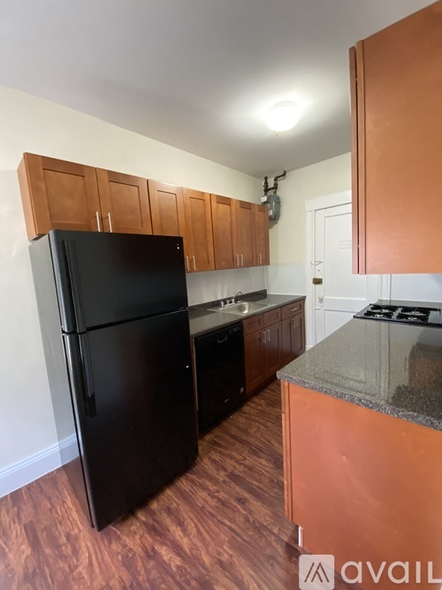 A kitchen with black appliances and wooden cabinets.