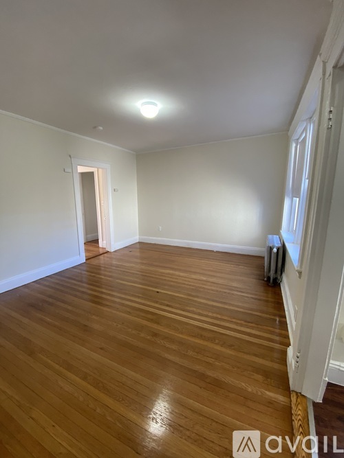 A room with wooden flooring and white walls.