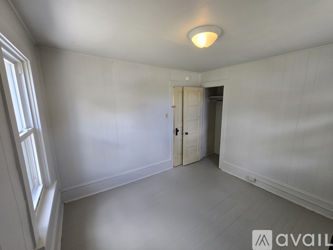 A white room with a door and a window.