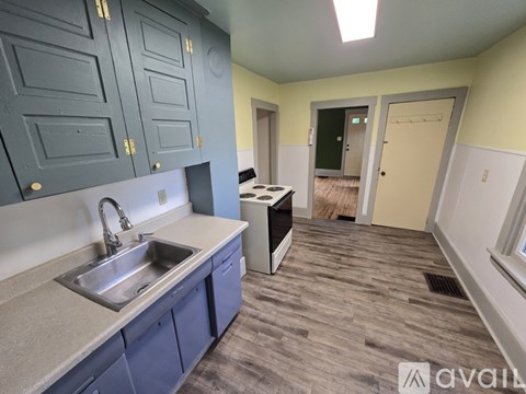 A kitchen with blue cabinets and a sink.