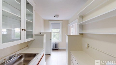 A kitchen with white cabinets and a stainless steel sink.