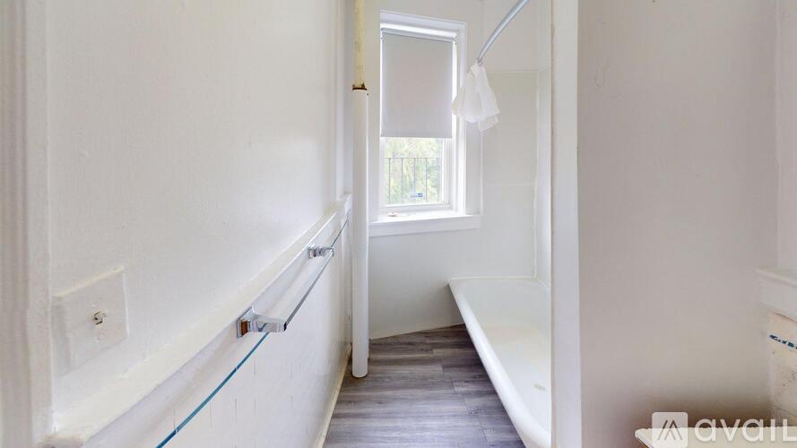 A long hallway with a window and a bench.