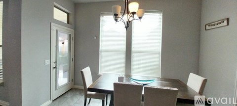 A dining room with a table and chairs.