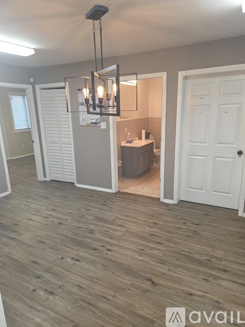 A room with wooden flooring and a chandelier.