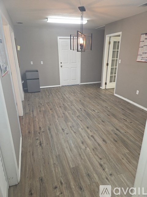 A room with wooden flooring and white doors.