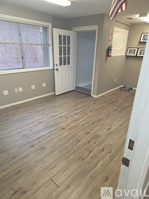 A room with wooden flooring and a white door.