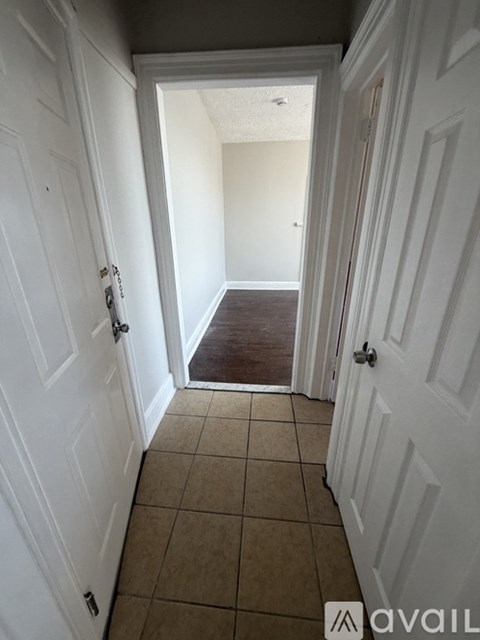 A hallway with white doors and tiled flooring.