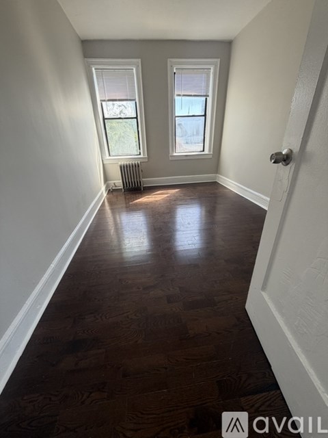 A hallway with wood floors and white walls.