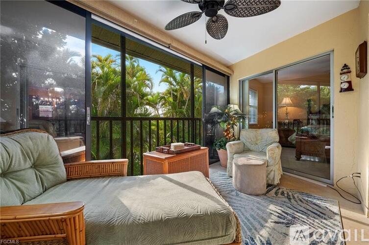 A bedroom with a bed, a couch, a chair, and a ceiling fan.