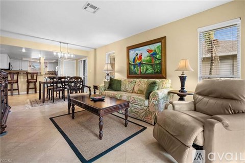 A living room with a brown coffee table and a painting of two people on a green background.