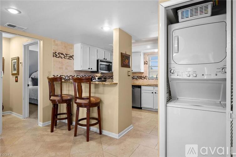 A kitchen with a white oven and a counter with a microwave.