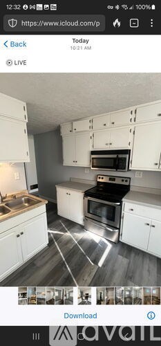 A kitchen with white cabinets and a black stove top oven.