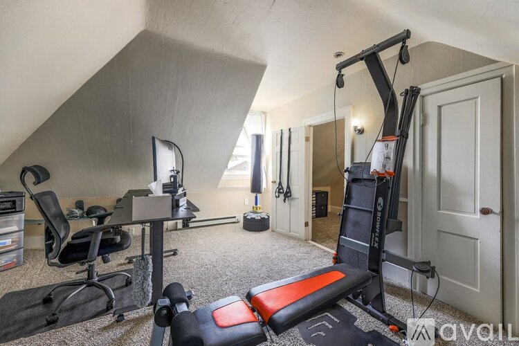 A home gym with a variety of equipment including a bench press, a squat rack, and a weightlifting bench.