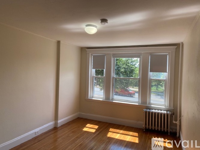 A room with a window and a radiator on the floor.