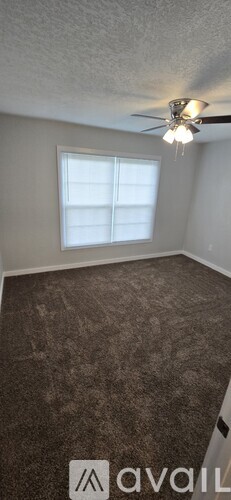 A room with a ceiling fan and a window.