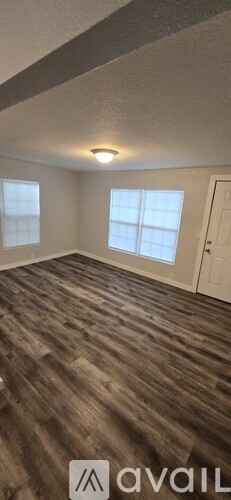 A room with wooden flooring and a white door.