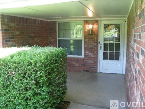 A white door is on the right side of a brick wall.