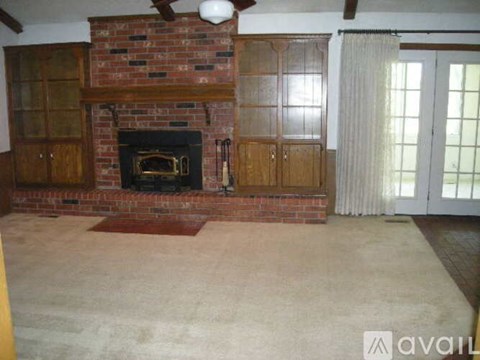 A living room with a fireplace and a ceiling fan.