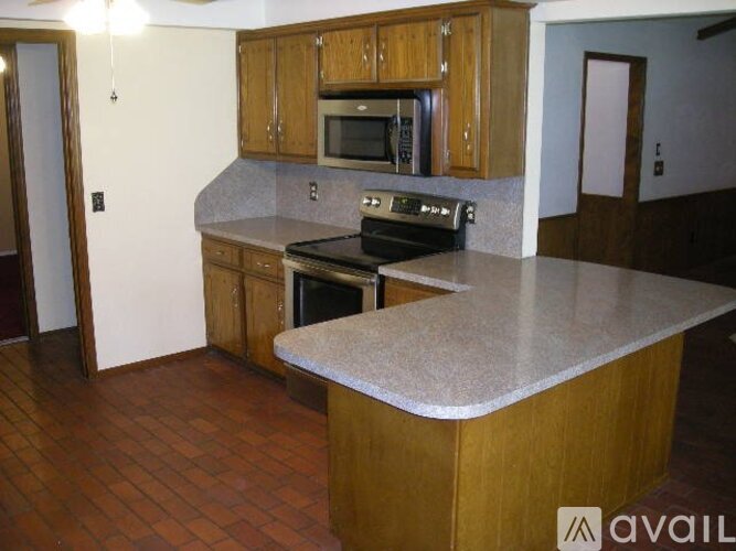 A kitchen with wooden cabinets and a granite countertop.