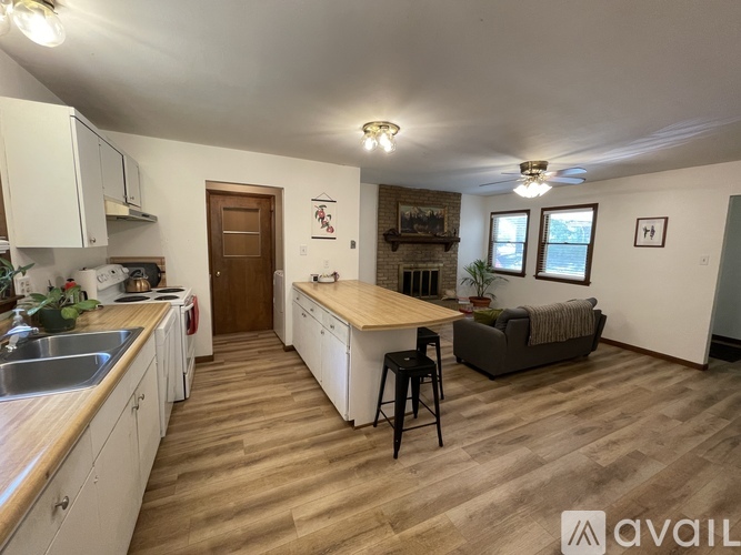 A kitchen with white cabinets and a wooden island.