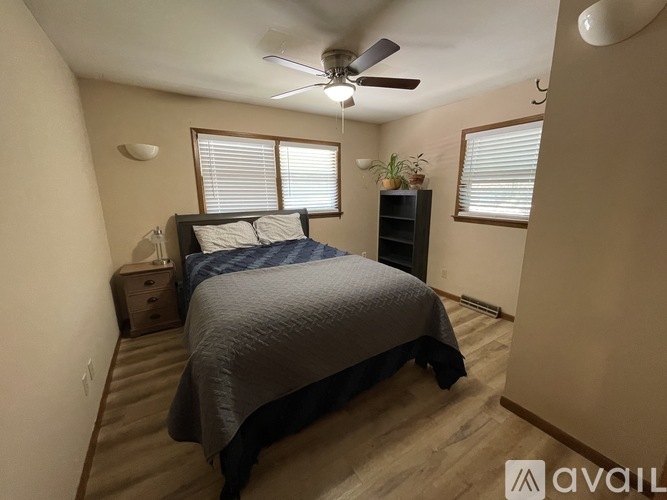 A bedroom with a bed, nightstand, and a ceiling fan.