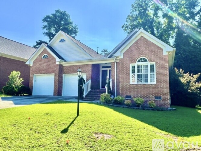 A house with a white garage door and a brick facade.