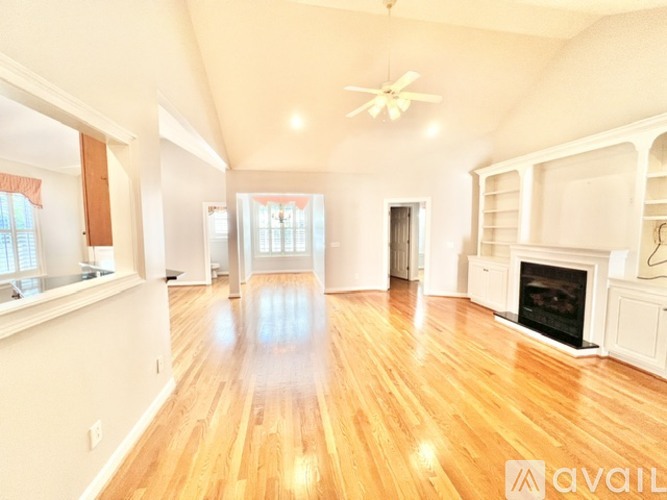 A spacious living room with hardwood floors and a fireplace.