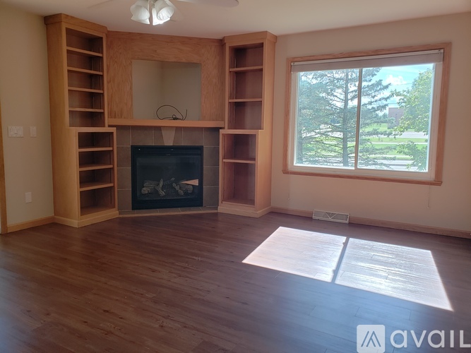 A living room with a fireplace and a large window.