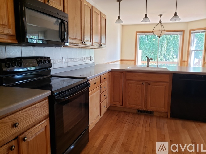A kitchen with wooden cabinets and black appliances.
