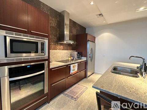 A kitchen with brown cabinets and a stainless steel oven.