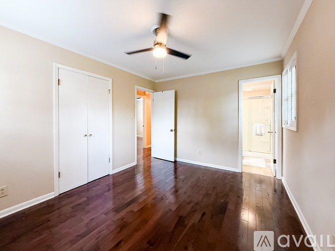 A room with a ceiling fan and wooden floors.