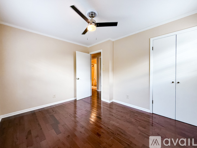 A room with a ceiling fan and wooden flooring.