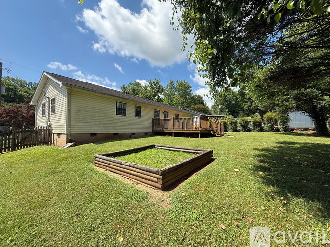 A backyard with a wooden deck and a small building.