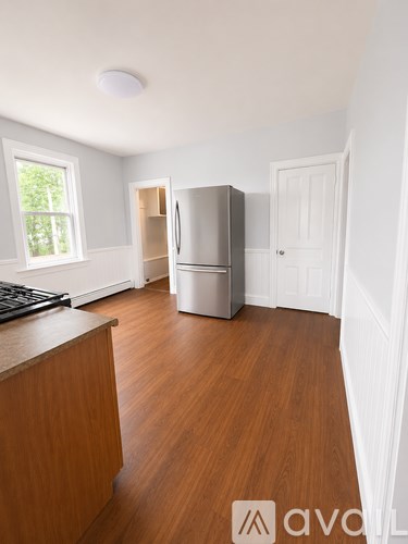 A kitchen with wooden floors and white walls.