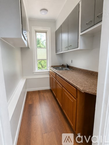 A kitchen with wooden floors and white walls.