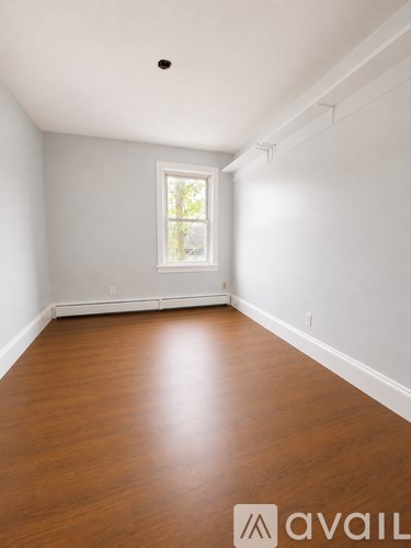 A room with wooden floors and a window.