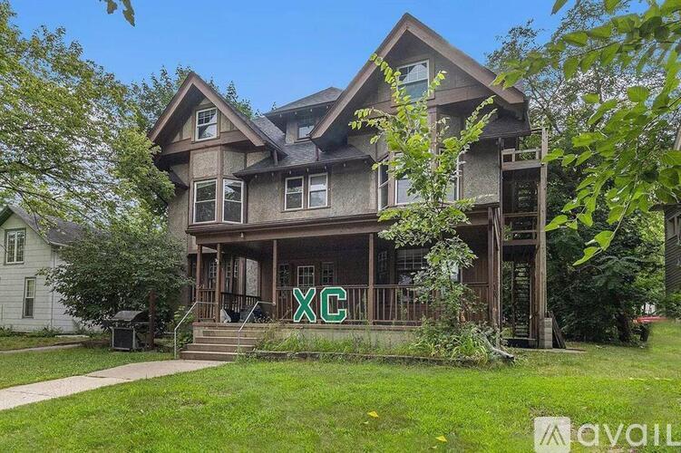 A house with a large front porch and a balcony on the second floor.