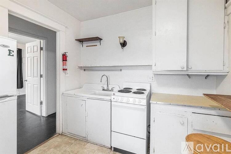 A kitchen with white appliances and cabinets.