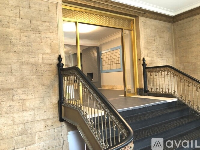 A staircase with a metal railing and a glass door leading to a hallway.