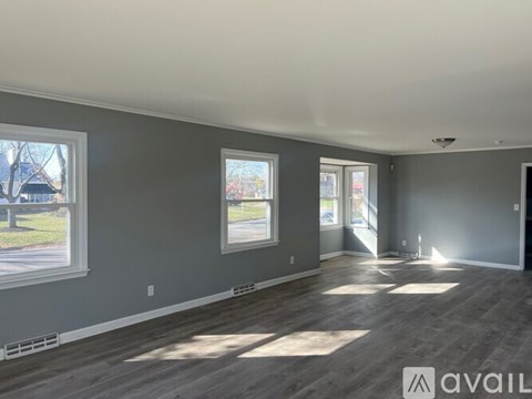 A spacious room with grey walls and wooden flooring is available for rent.