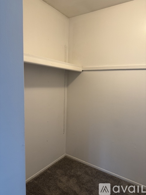 A small, empty room with a carpeted floor and white walls.