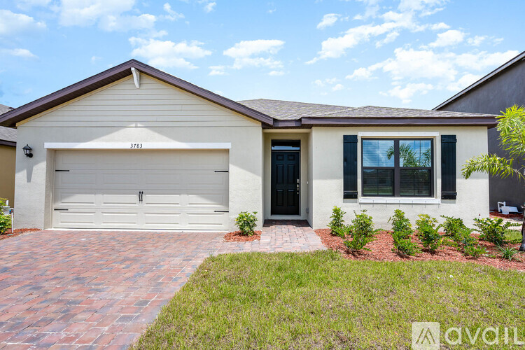 A house with a garage and a driveway in front.