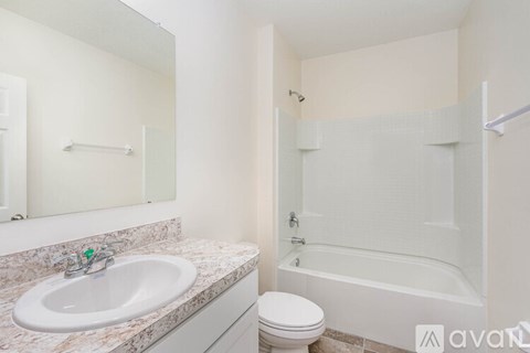 A bathroom with a sink, toilet, and bathtub.
