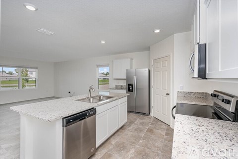 A kitchen with white cabinets and a granite counter top.
