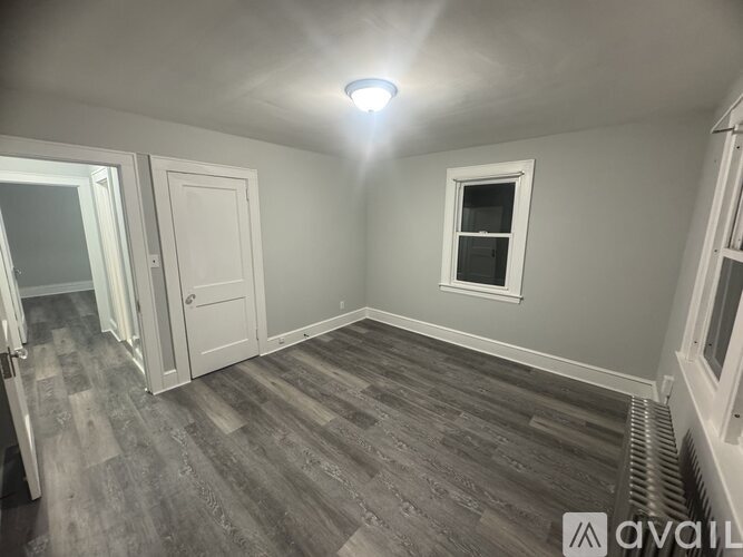 A room with a window and a door is available for rent.