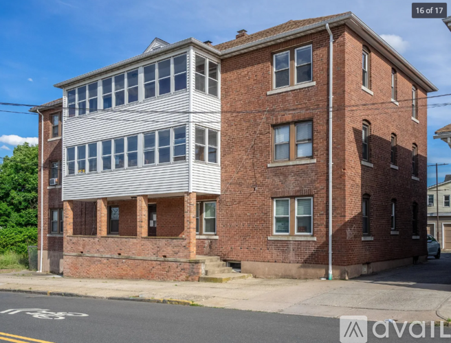 A two-story brick building with a white-framed window on the second floor.