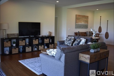 A living room with a grey couch and a wooden coffee table.