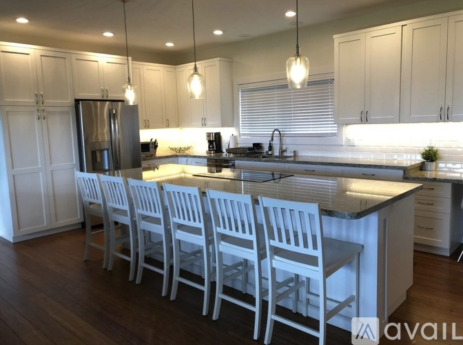 A kitchen with white cabinets and a black countertop.